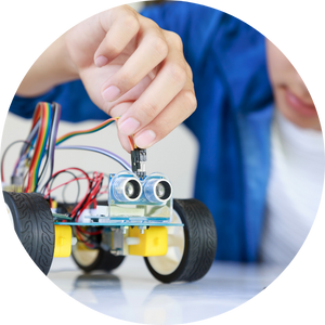  young boy plugging energy and signal cables into robotic car